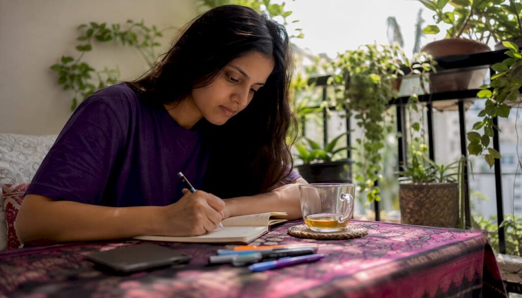 Woman journaling mood at kitchen table